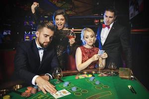 Group of rich people is playing poker in the casino photo