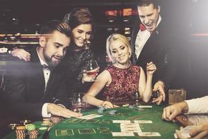 Group of rich people is playing poker in the casino photo