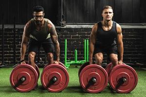 Muscular men during competition in the farmer's walk exercise photo