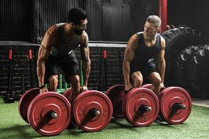 Muscular men during competition in the farmer's walk exercise photo