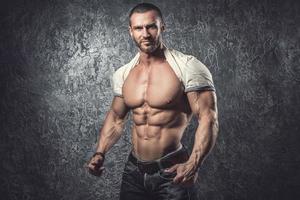 Man showing his body against concrete wall photo