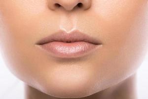 Cerca de hermosos labios femeninos sobre fondo blanco. foto