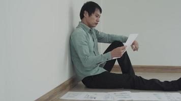 Stressed and headache asian man with large bills or invoices no money to pay to expenses and credit card debt. shortage, Financial problems, mortgage, loan, bankruptcy, bankrupt, poor, empty wallet video
