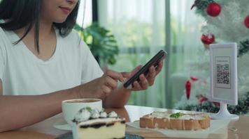 vrouw gebruik smartphone naar scannen qr code naar betalen in cafe restaurant met een digitaal betaling zonder contant geld. Kiezen menu en bestellen accumuleren korting. e portemonnee, technologie, betalen online, credit kaart, bank app video