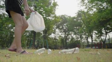 une femme empêche la bouteille en plastique de faire de l'exercice, les gens jetés dans le parc. bouteilles en plastique difficiles à décomposer et à prévenir les dommages à la vie aquatique. sauver le concept du monde. video