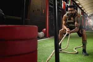 Sled drag exercise. Sportsman during his cross training workout. photo