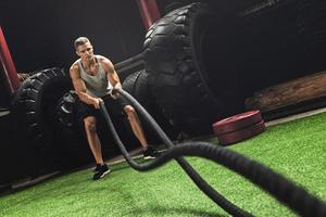 Man is making battle rope exercises during his cross training workout photo