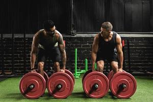 Muscular men during competition in the farmer's walk exercise photo