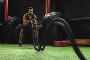 Man is making battle rope exercises during his cross training workout photo