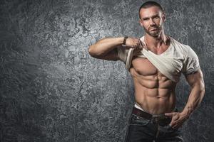 Man showing his body against concrete wall photo