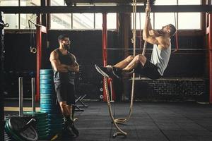 Sportsman and his trainer during workout in the gym photo