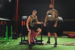 Two men teammates wearing weight vests during workout photo