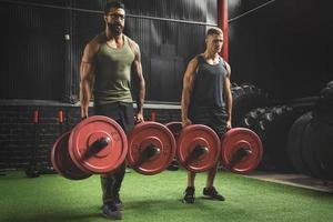 hombres musculosos durante la competencia en el ejercicio de caminata del granjero foto