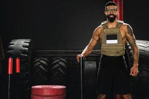 Sportsman wearing weight vest during his workout in the gym photo