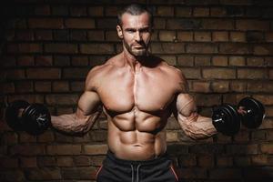 Bodybuilder doing exercises for biceps with a dumbbells photo
