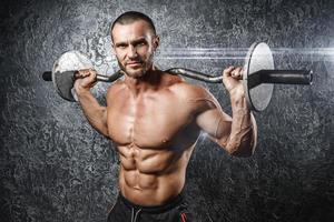 Handsome muscular bodybuilder exercising with a barbell photo