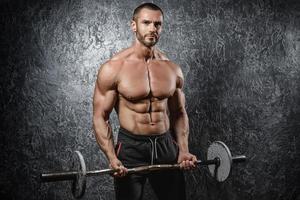 Handsome muscular bodybuilder exercising with a barbell photo