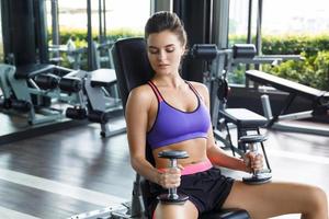 Woman working out with dumbbells in gym photo