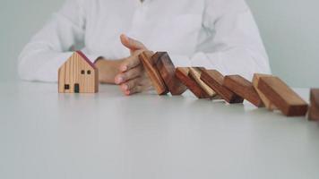 Versicherung mit Händen schützen Domino. geschäftsmannhände stoppen dominosteine, die in geschäftskrisen fallen. Kontrolle und Planung von Geschäftsrisiken sowie Strategien zur Führung von Versicherungsgeschäften. video