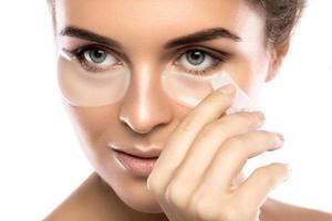 Woman with collagen pads under her eyes photo