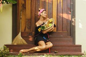 Beautiful woman sitting on the doorstep beside her house photo