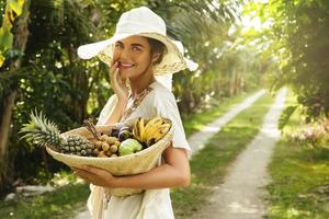 Beautiful woman wearing broad-brim hat in the tropical garden photo