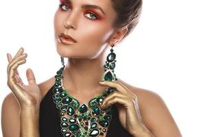 Sexy woman wearing big beautiful necklace and earrings with a lot of gems photo