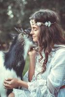 Beautiful woman with a funny friendly goat in the village photo