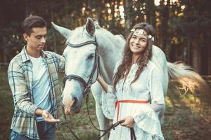 Young couple taking care about beautiful horse photo