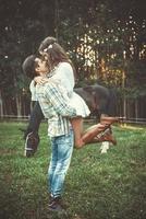 Young couple in embrace on the meadow with a horses photo