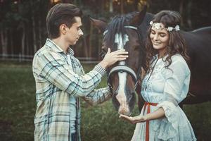 Young couple taking care about beautiful horse photo