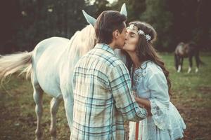 Portrait of young happy couple and beautiful horse photo