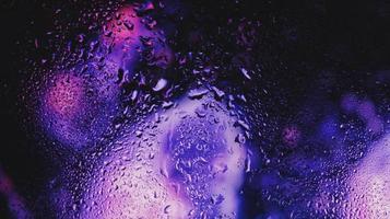 Purple Neon Blurred Lights Through Glass Window With Raindrops On It in Karachi Pakistan 2022 photo