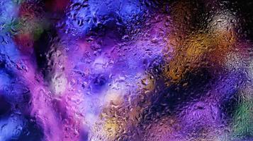 Purple Neon Blurred Lights Through Glass Window With Raindrops On It in Karachi Pakistan 2022 photo