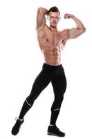 Young man bodybuilder showing his muscles in studio photo