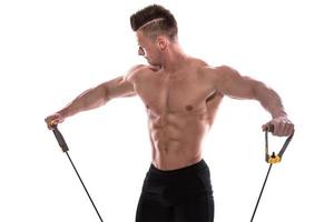 Bodybuilder working out with rubber band over white background photo