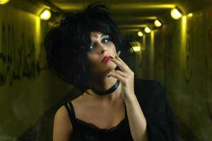 Freaky woman with black hair smoking a cigarette photo