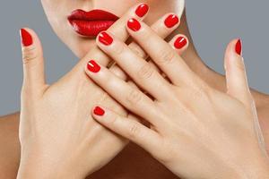 Beauty and cosmetics. Female mouth and nails with red manicure and lipstick. photo