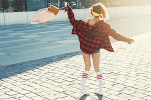 Happy stylish girl with backpack on street photo