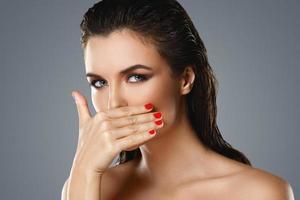 Portrait of beautiful young woman with a red lipstick and nail polish photo