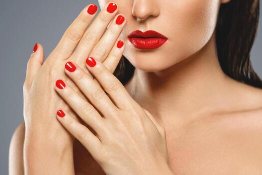 Beauty and cosmetics. Female mouth and nails with red manicure and lipstick. photo