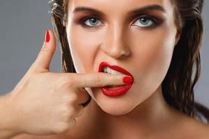 retrato de una bella joven con pintalabios rojo y esmalte de uñas foto