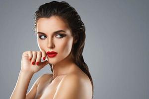 Portrait of beautiful young woman with a red lipstick and nail polish photo