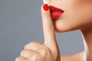 Woman is showing shush or silence gesture photo