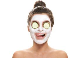 Woman with facial mask and cucumber slices on her eyes photo