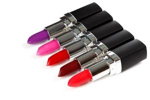 Lipsticks tubes of different colors on white background photo