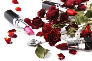 Closeup of lipstick and dried rose flowers photo
