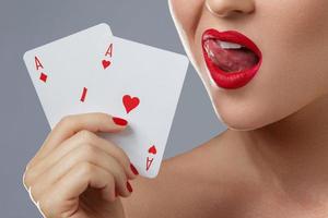 Woman with red lips is holding two aces. photo