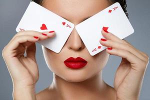 Woman with red lips is holding two aces in her hands photo