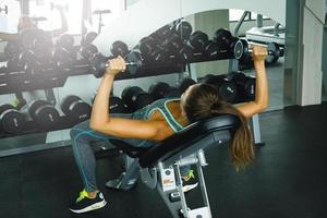 Woman working out with dumbbells in gym photo